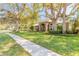 Elegant home with lush lawn, mature trees, arched entryway, and a fenced front yard at 6049 Sabal Hammock Cir, Port Orange, FL 32128