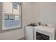 Bright laundry room with modern, white washer and dryer, and a sunlit window at 606 Yupon Ave, New Smyrna Beach, FL 32169