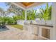 Modern outdoor kitchen equipped with stainless steel appliances and ample counter space at 606 Yupon Ave, New Smyrna Beach, FL 32169