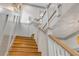 Elegant staircase with hardwood steps and white railings, illuminated by modern wall sconces at 606 Yupon Ave, New Smyrna Beach, FL 32169