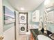 Bathroom featuring laundry closet, decorative mirror, stylish fixtures, and a sink at 61 Cedar Dunes Dr, New Smyrna Beach, FL 32169