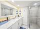 Bathroom featuring double sink vanity with marble countertop and glass shower at 61 Cedar Dunes Dr, New Smyrna Beach, FL 32169