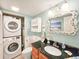 Bathroom featuring laundry closet, decorative mirror, stylish fixtures, and a sink at 61 Cedar Dunes Dr, New Smyrna Beach, FL 32169