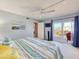 Bright bedroom leads to private balcony with ceiling fan and beach themed décor at 61 Cedar Dunes Dr, New Smyrna Beach, FL 32169