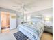 Bright bedroom featuring a striped bedspread, ceiling fan, and ensuite bathroom at 61 Cedar Dunes Dr, New Smyrna Beach, FL 32169