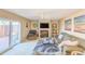 Comfortable living room featuring a fireplace, ceiling fan, patio access, and neutral-toned furniture and decor at 61 Cedar Dunes Dr, New Smyrna Beach, FL 32169