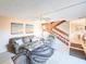 Inviting living room with a ceiling fan, staircase, beach-themed art, and access to other rooms in the home at 61 Cedar Dunes Dr, New Smyrna Beach, FL 32169