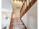 Carpeted staircase with wooden railing, track lights, and a unique hanging light fixture at 61 Cedar Dunes Dr, New Smyrna Beach, FL 32169