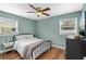 Cozy bedroom with natural light, ceiling fan, wood floors, and black iron bedframe at 612 Cedar Park Dr, Daytona Beach, FL 32114