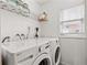 Functional laundry room with washer, dryer, and storage shelf at 612 Cedar Park Dr, Daytona Beach, FL 32114