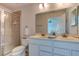 Bathroom featuring a double vanity, and a glass enclosed tiled shower, offering comfort and convenience at 612 Mount Olympus Blvd, New Smyrna Beach, FL 32168