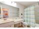 Well-organized bathroom with a vanity area, toilet, and a bathtub with a stylish striped curtain at 612 Mount Olympus Blvd, New Smyrna Beach, FL 32168