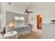 Bright bedroom featuring a ceiling fan, large window with a view, and an attached bathroom at 612 Mount Olympus Blvd, New Smyrna Beach, FL 32168