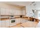 Modern kitchen featuring white appliances, ample countertop space, and a view of the stairs at 612 Mount Olympus Blvd, New Smyrna Beach, FL 32168
