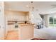 Open-concept kitchen with white appliances, a breakfast bar, and seamless flow into the living room at 612 Mount Olympus Blvd, New Smyrna Beach, FL 32168