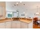 Well-lit kitchen with white appliances, modern fixtures, and an open layout to the living area at 612 Mount Olympus Blvd, New Smyrna Beach, FL 32168