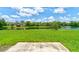 Scenic lake view with lush green grass and blue skies filled with fluffy white clouds, showcasing a serene outdoor setting at 612 Mount Olympus Blvd, New Smyrna Beach, FL 32168