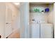 Convenient laundry area with washer, dryer, and shelving for storage, located near a hallway with natural light at 612 Mount Olympus Blvd, New Smyrna Beach, FL 32168