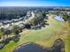 Aerial view of homes along the golf course and pond, set against a backdrop of dense woods at 6456 Cypress Springs Pkwy, Port Orange, FL 32128