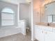 Bright primary bathroom with a soaking tub, and white cabinetry at 6456 Cypress Springs Pkwy, Port Orange, FL 32128
