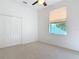 Well-lit bedroom featuring neutral carpet, a ceiling fan, and a large window with ample natural light at 6456 Cypress Springs Pkwy, Port Orange, FL 32128