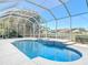 Sparkling in-ground pool with elegant blue tile accents, surrounded by a screened enclosure for year-round enjoyment at 6456 Cypress Springs Pkwy, Port Orange, FL 32128