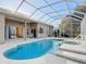 Inviting in-ground pool and spa in a screened enclosure, offering a private oasis for relaxation and entertainment at 6456 Cypress Springs Pkwy, Port Orange, FL 32128