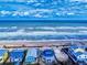 Beachfront homes with direct access to the sandy shorelines and ocean waves under a sunny sky at 6584 Engram Rd # 405, New Smyrna Beach, FL 32169