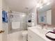 Bathroom with a shower featuring sliding glass doors, white storage shelves and a white vanity at 6584 Engram Rd # 405, New Smyrna Beach, FL 32169