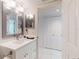 Well-lit bathroom featuring a single sink vanity with white cabinets and a framed mirror at 6584 Engram Rd # 405, New Smyrna Beach, FL 32169