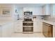 Modern kitchen showcasing stainless steel appliances, tiled backsplash, and white cabinets at 6584 Engram Rd # 405, New Smyrna Beach, FL 32169