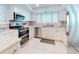 Bright kitchen featuring white cabinets, stainless steel appliances, and sleek countertops with a tile backsplash at 6584 Engram Rd # 405, New Smyrna Beach, FL 32169