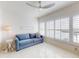 Comfortable living room with a blue sofa, a white lamp, and bright white shutters at 6584 Engram Rd # 405, New Smyrna Beach, FL 32169