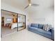 Cozy living room featuring a blue sofa and sliding glass doors leading to a bedroom with a view at 6584 Engram Rd # 405, New Smyrna Beach, FL 32169