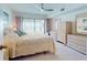 Calm main bedroom with wicker dressers, ceiling fan, large bed, and sliding doors to a lanai at 6584 Engram Rd # 405, New Smyrna Beach, FL 32169