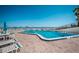 Sparkling swimming pool offers refreshing relief with ocean views, surrounded by lounge chairs and umbrellas at 701 S Atlantic Ave # 11, New Smyrna Beach, FL 32169