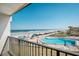 Balcony view of community pool and beach with lounge chairs, umbrellas, and the ocean beyond at 701 S Atlantic Ave # 11, New Smyrna Beach, FL 32169
