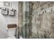 Modern bathroom with a glass-enclosed shower featuring gray tiles, a shower head and a bench at 701 S Atlantic Ave # 11, New Smyrna Beach, FL 32169