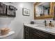 Bathroom featuring a dark vanity with white countertop and a decorative gold mirror at 701 S Atlantic Ave # 11, New Smyrna Beach, FL 32169