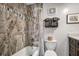 Bathroom featuring a tub with marble-look tile surround, a gray vanity, and matching towels at 701 S Atlantic Ave # 11, New Smyrna Beach, FL 32169