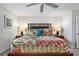 Well-lit bedroom showcasing a wooden headboard bed, patterned quilt, and matching lamps on each side at 701 S Atlantic Ave # 11, New Smyrna Beach, FL 32169