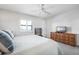 Bright bedroom featuring large window with plantation shutters and a woven dresser with a TV at 701 S Atlantic Ave # 11, New Smyrna Beach, FL 32169