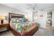 Comfortable bedroom with a colorful bedspread, ceiling fan, and an ensuite bathroom with a toilet at 701 S Atlantic Ave # 11, New Smyrna Beach, FL 32169