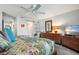 Serene bedroom featuring a sliding door to the bathroom, dresser, mirror and a ceiling fan at 701 S Atlantic Ave # 11, New Smyrna Beach, FL 32169