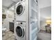 Modern laundry area featuring a stackable washer and dryer and a sliding barn door at 701 S Atlantic Ave # 11, New Smyrna Beach, FL 32169