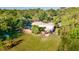 Aerial view of home with large lawn, lush trees, shed, and metal carport at 725 Ingham Rd, New Smyrna Beach, FL 32168