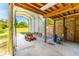 View of open carport with lawnmower and tools adjacent to enclosed storage area at 725 Ingham Rd, New Smyrna Beach, FL 32168