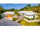 Stunning exterior view of a one-story home showcasing meticulous landscaping and a three-car garage at 725 Ingham Rd, New Smyrna Beach, FL 32168