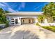 Front of garage with white facade, updated glass door and interior shelving at 725 Ingham Rd, New Smyrna Beach, FL 32168