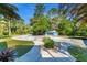 Driveway leading to a detached blue garage amidst lush greenery at 725 Ingham Rd, New Smyrna Beach, FL 32168